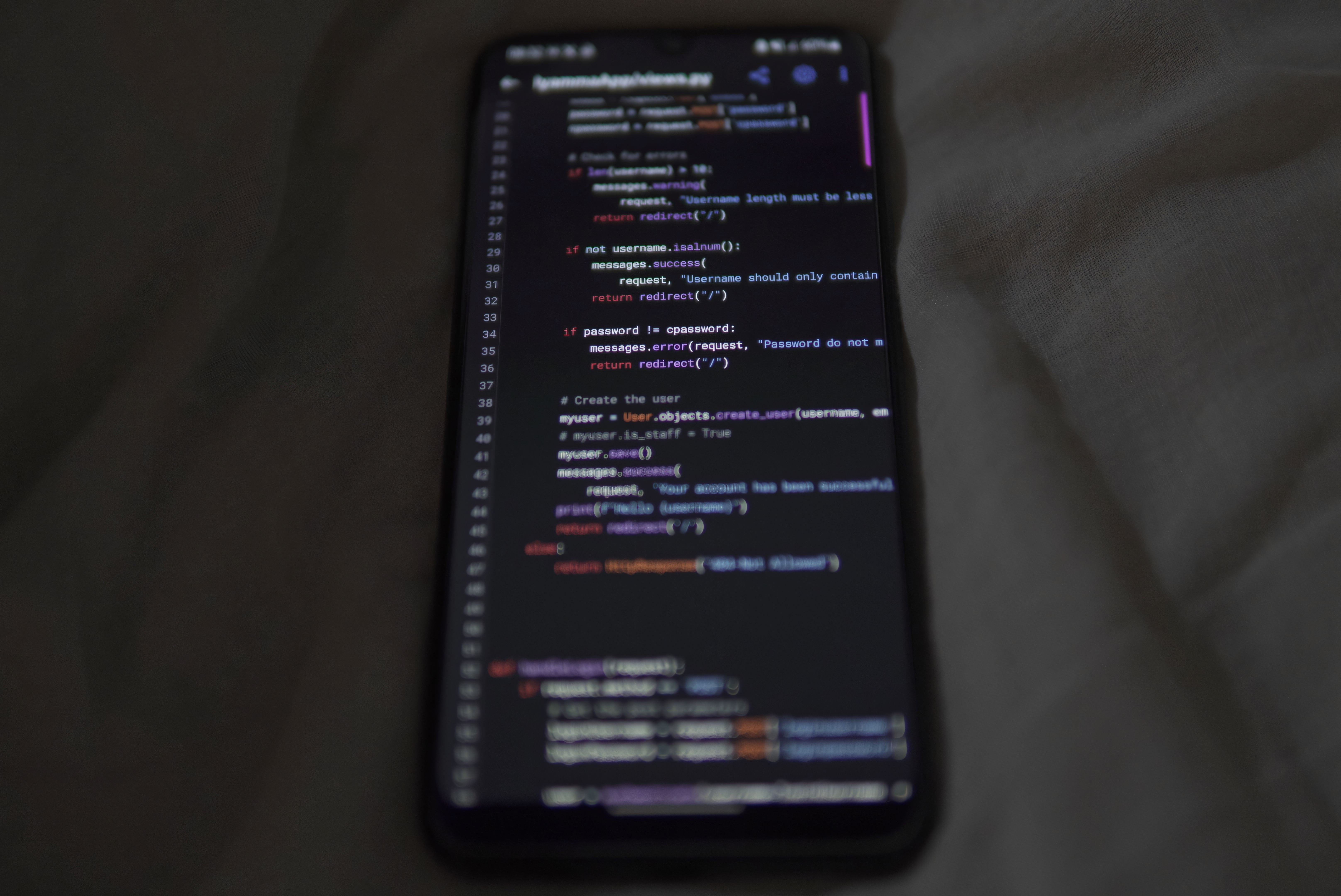 Mobile app source code displayed on a smartphone screen